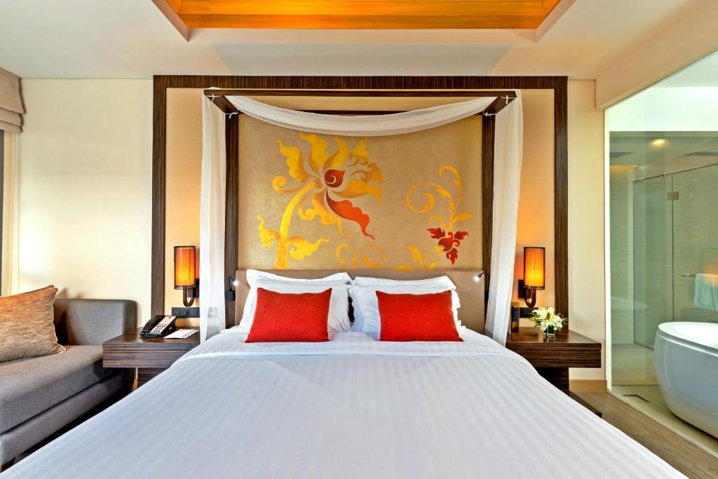 Mūsdienīgs numurs ar māksliniecisku sienu un sarkaniem akcentiem Grand Mercure Phuket Patong.