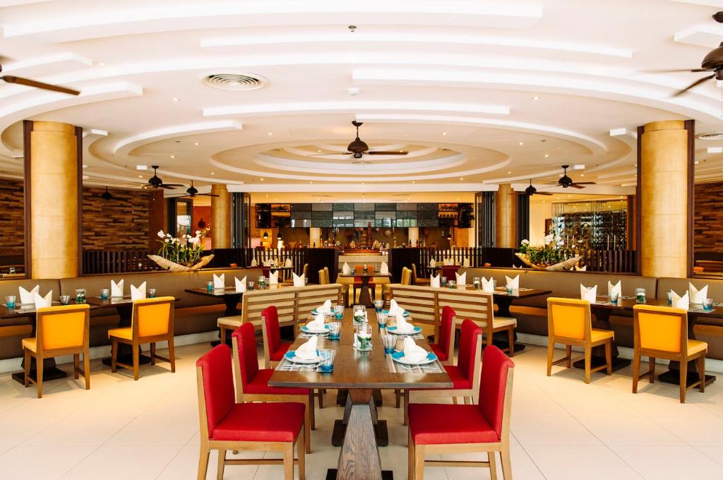 Restorāns Grand Mercure Phuket Patong ar elegantu interjeru un krāsainām mēbelēm.