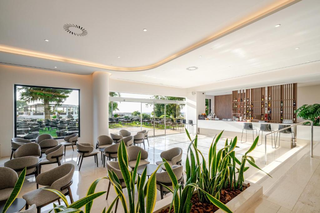 Mūsdienīgs bārs Calypso Beach ar elegantiem krēsliem un skatu uz dārzu.