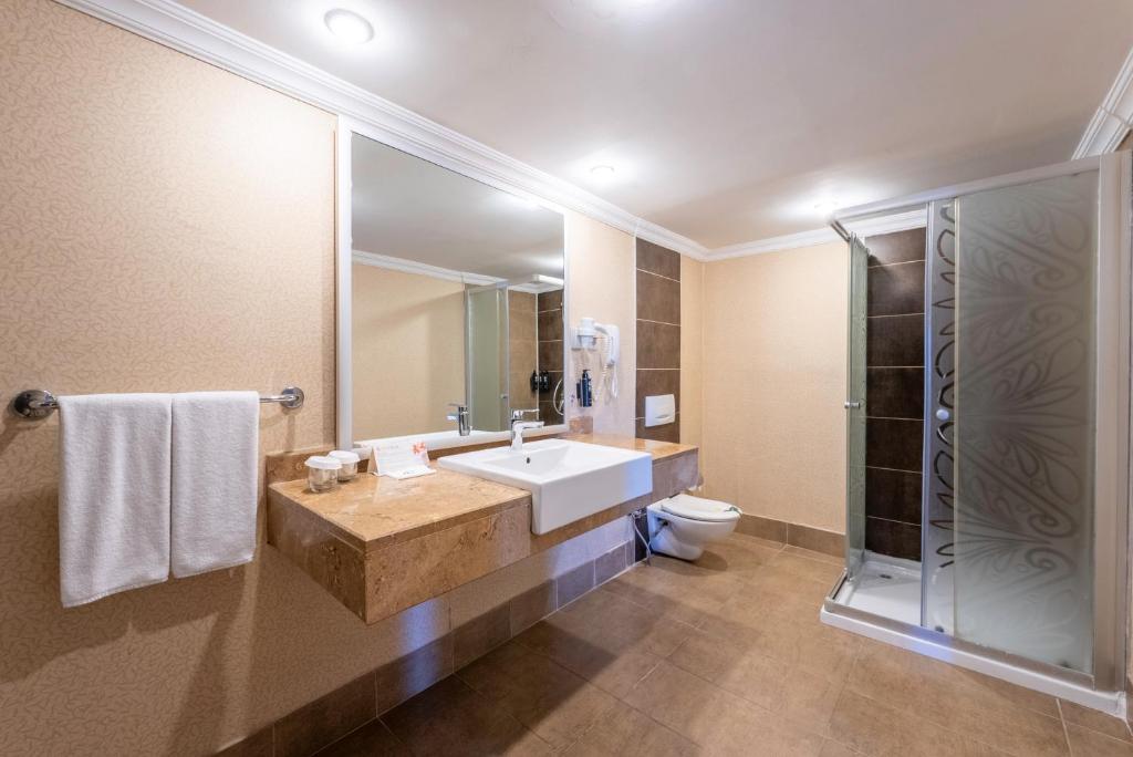 Mūsdienīgs vannas istabas interjers viesnīcā Kaya Belek ar dušu un izsmalcinātām detaļām.
