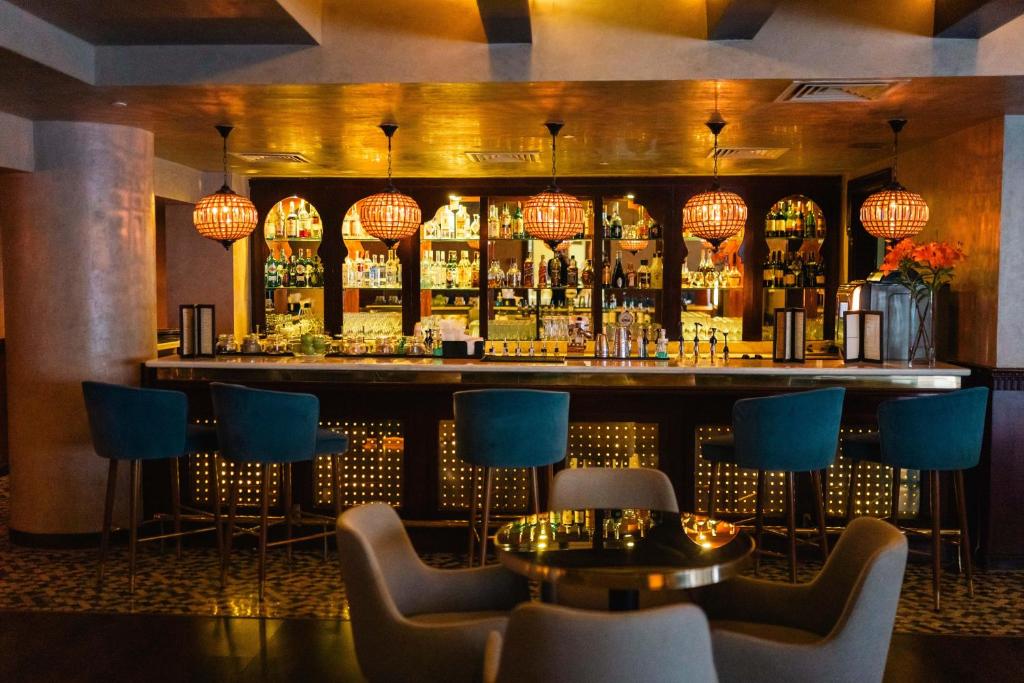 Eleganti iekārtots bārs viesnīcā Baron Palms Resort ar krāsainiem apgaismojuma elementiem.