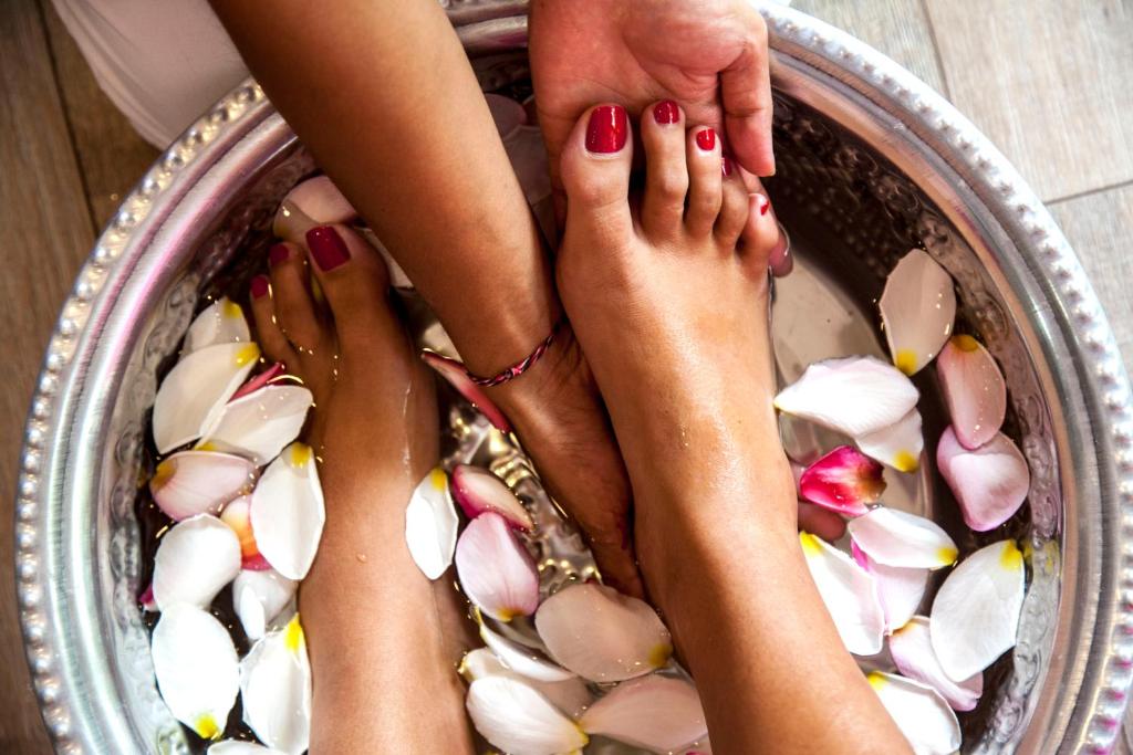Kāju vannošana ar rožu ziedlapiņām un manikīru, kas sniedz relaksāciju un komfortu. Ideāla aina spa procedūrai.