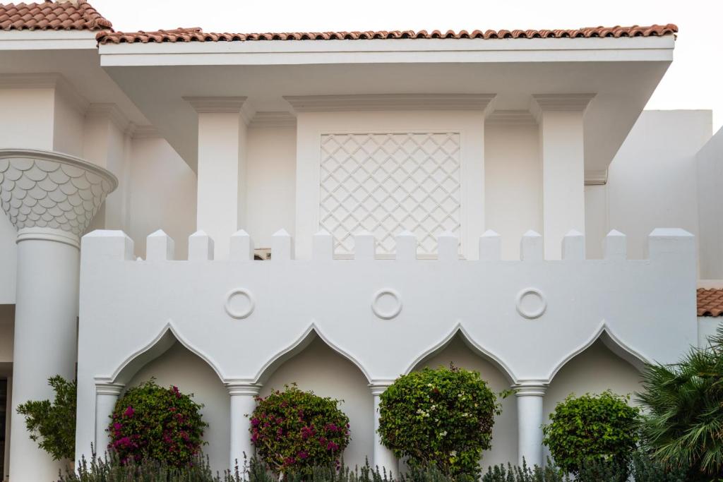 Baron Palms Resort arhitektūras detaļas ar baltiem mūriem un zaļām augiem.