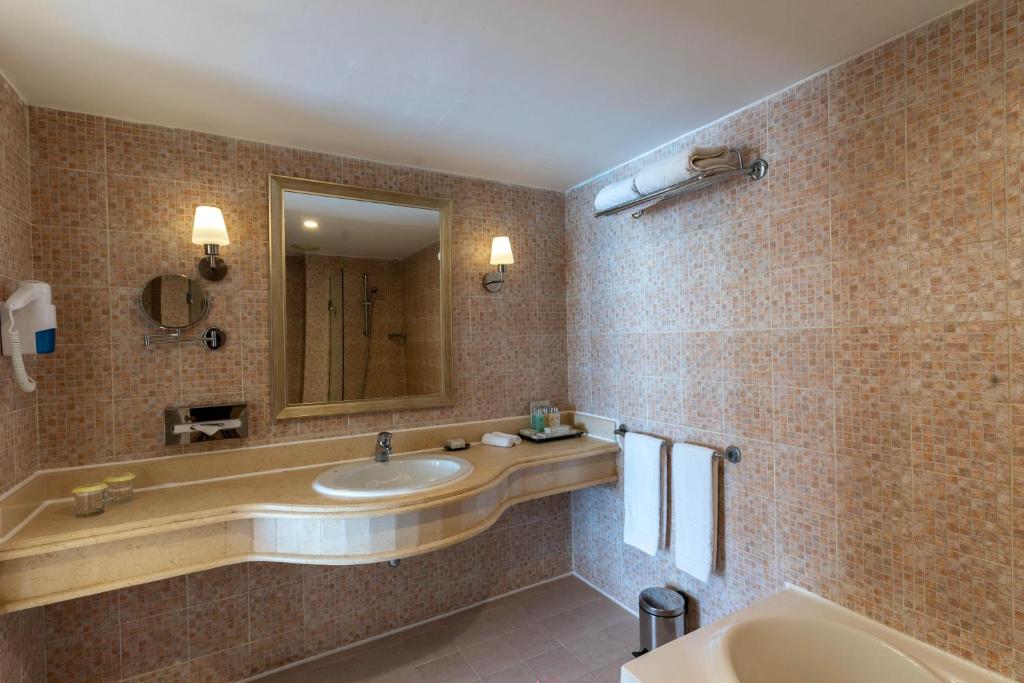 Mūsdienīgs vannas istaba ar dušu un elegantu dizainu hotelī Baron Palms Resort.