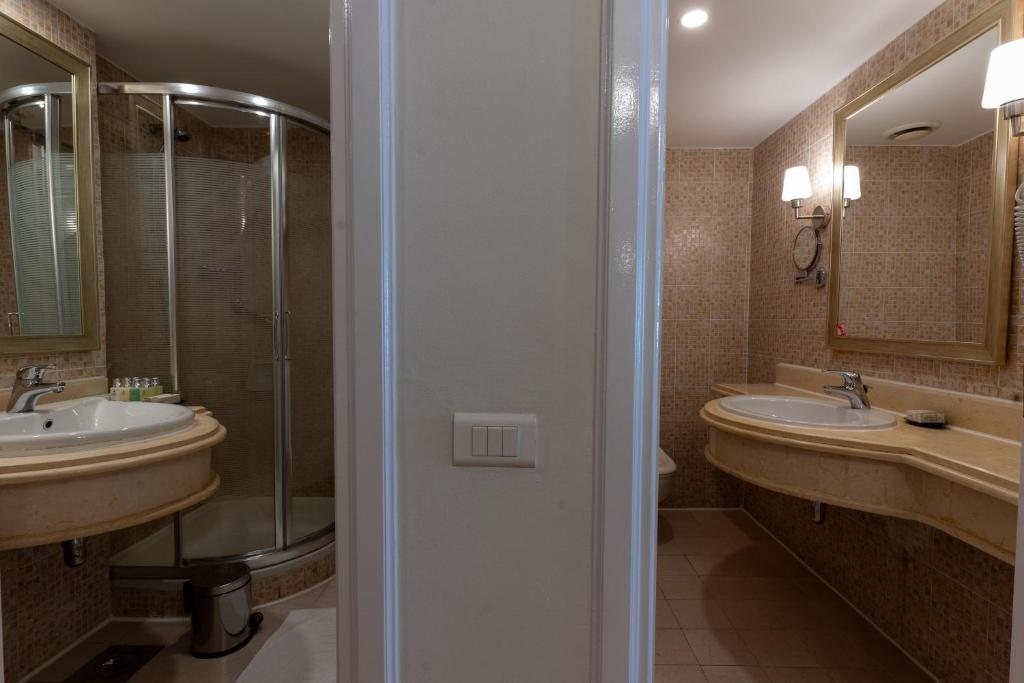 Mūsdienīgs vannas numurs ar dušu un divām izlietnēm Baron Palms Resort.