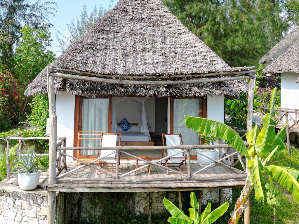 Zanbluu Beach tradicionāls bungalo ar terasi tropiskā vidē.