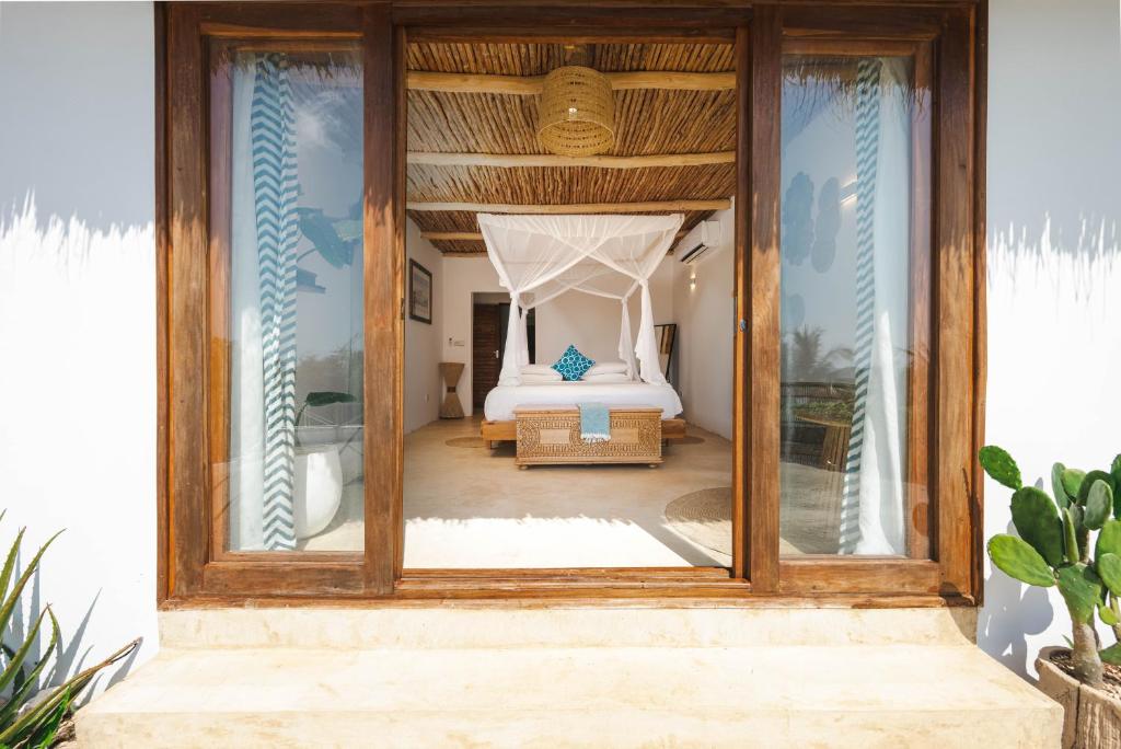 Zanbluu Beach numurs ar skatu uz okeānu un baldahīna gultu.