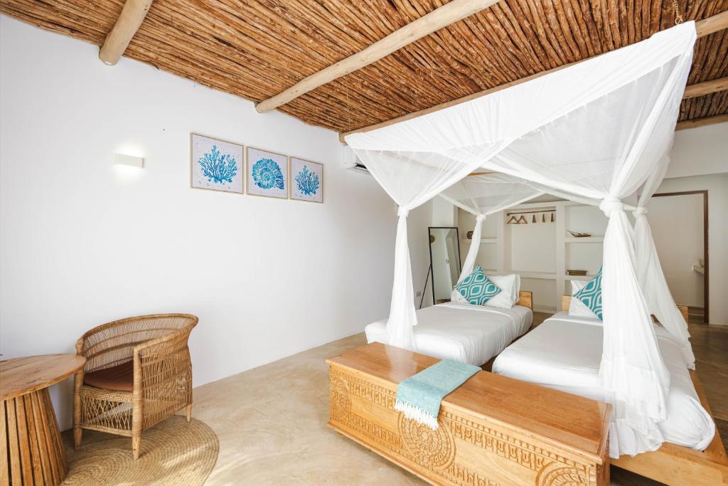 Zanbluu Beach numurs ar divām gultām un baldahīnu.