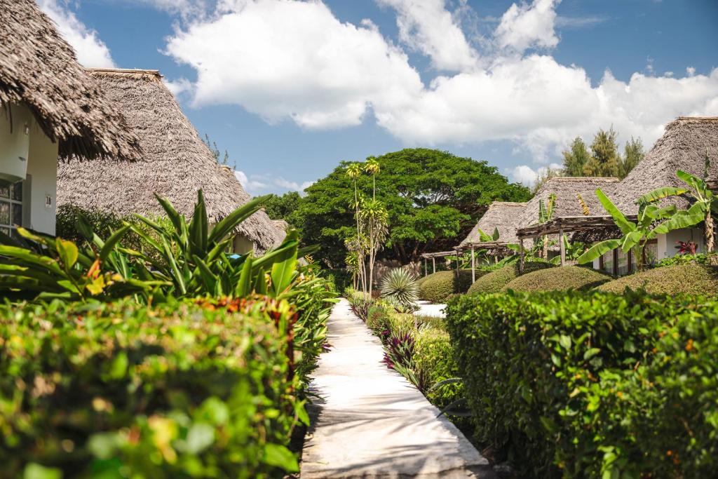 Zanbluu Beach bungalo dārza vidū ar tropu ainavu.