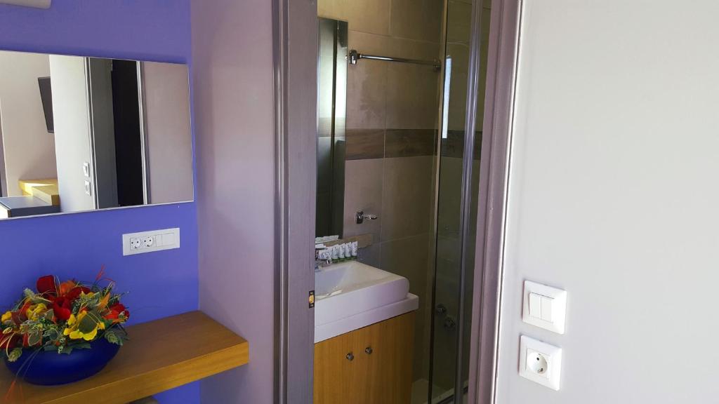 Moderns vannas istabas skats Sunny Days Hotel-Apartments, ar ziediem uz galda.