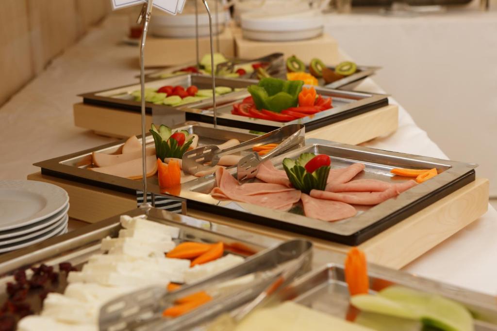 Svaigi sagatavotais uzkodu galds ar dažādiem dārzeņiem, gaļu un sieriem, kas ir izkārtoti estētiskā veidā. Ideāli piemērots svinībām un pasākumiem.