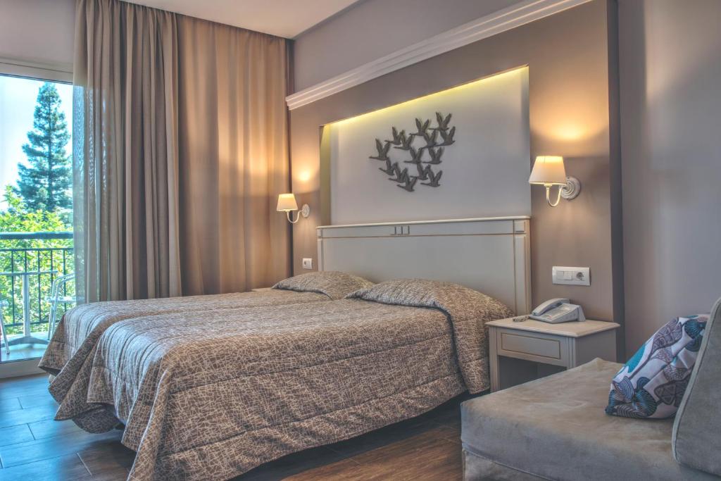 Mūsdienīgs viesnīcas numurs ar divām gultām, stilīgu apgaismojumu un skatu uz dabu. Interjerā izmantotas neitrālas krāsas un mīkstas tekstūras, radot relaksējošu atmosfēru.