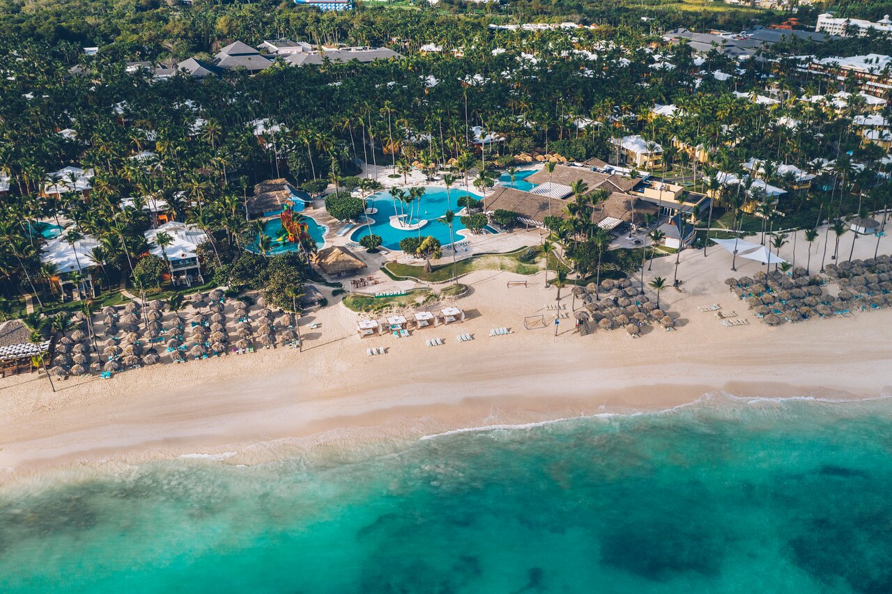 Tropu kūrorts ar baseiniem, pludmali un palmām, kas atrodas pie kristāldzidra ūdens. Rāms un relaksējošs atpūtas galamērķis. panoramic view with beach and pools