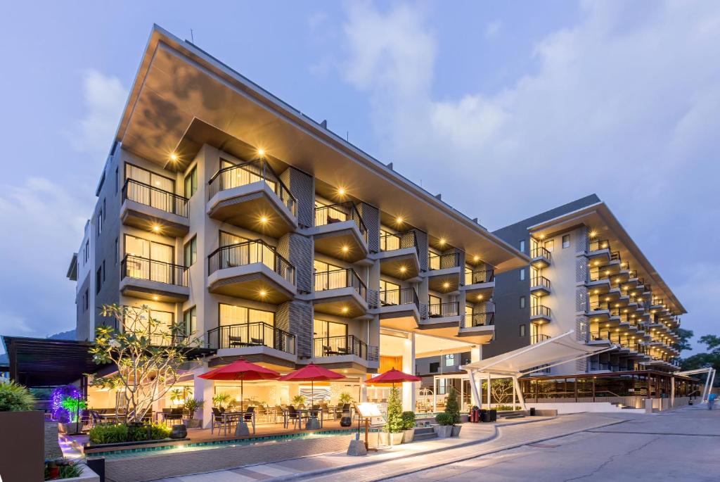 Mūsdienīgs viesnīcas komplekss ar stilīgu arhitektūru, gaišām fasādēm un terasēm, kas piedāvā viesu ērtības un relaksācijas iespējas. Apgaismota ēka pievērš uzmanību vakara stundās.