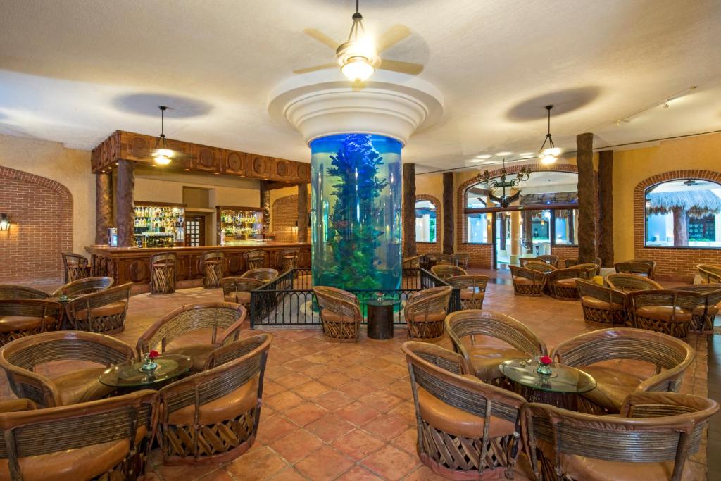 Elegantais bārs ar tropisku akvāriju centrā, iekārtots ar rattan krēsliem un stikla galdiem, radot relaksējošu atmosfēru. Ideāla vieta atpūtai un sociālām tikšanām.