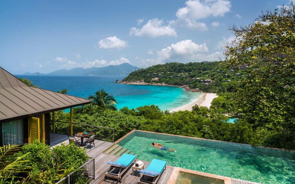 Four Seasons Resort Seychelles privātā villa ar bezgalības baseinu un skatu uz tirkīzzilo līci.