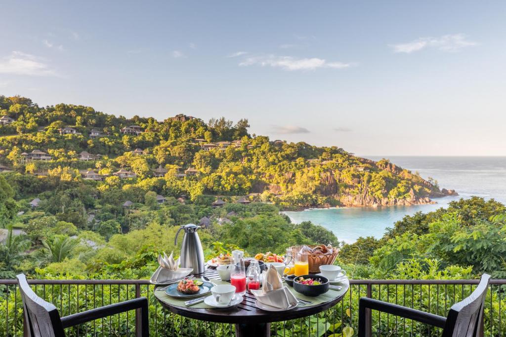 Brokastis uz terases Four Seasons Resort Seychelles ar skatu uz tropu zaļumiem un līci