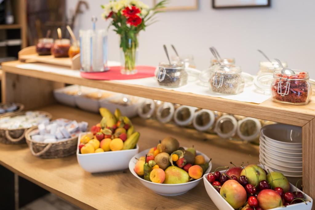 Svaigu augļu un riekstu bufete ar dažādām garšvielām un ievārījumiem, dekorēta ar ziediem. Ideāla vieta veselīgajām brokastīm vai uzkodām.