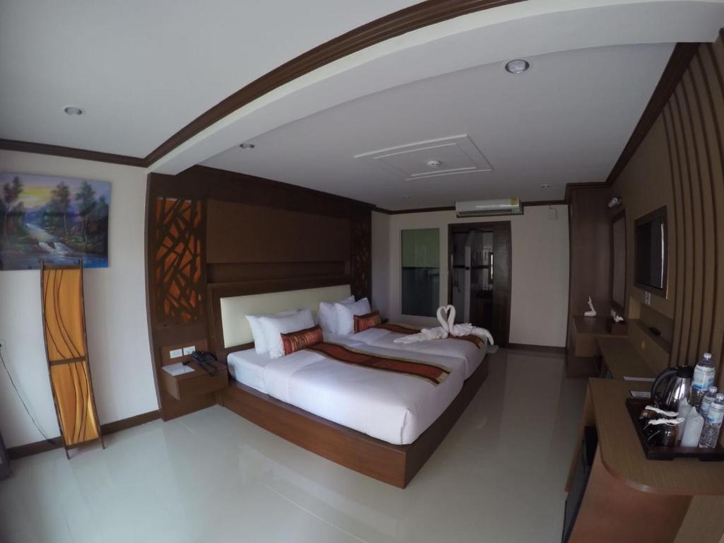 Mūsdienīgs numurs Chivatara Resort Bangtao ar divām gultām un iekārtotu interjeru.