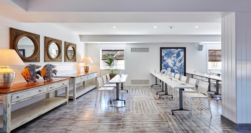 Moderns sanāksmju telpas interjers ar koka grīdu, lielām logu atverēm un radošiem dekoratīviem elementiem. Telpā ir gaišas krāsas un ērti galdi, kas piemēroti sapulcēm.