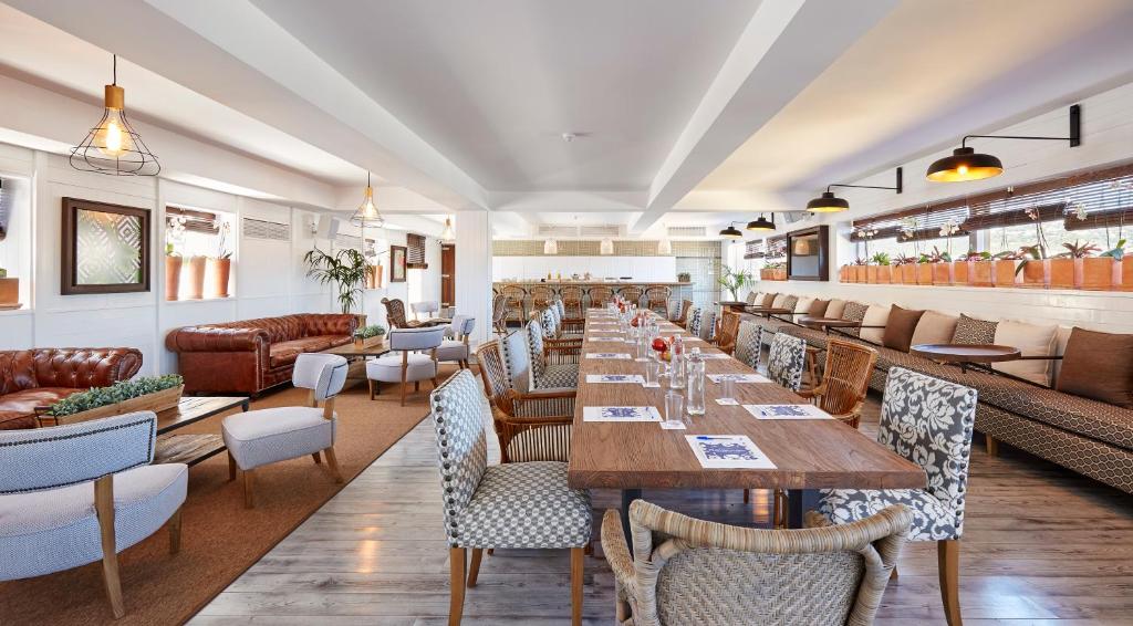 Moderns restorāns ar elegantu interjeru, kurā apvienotas dažādas sēdvietas un garšīgas pusdienu galdi. Gaismas un augu elementi rada patīkamu atmosfēru.