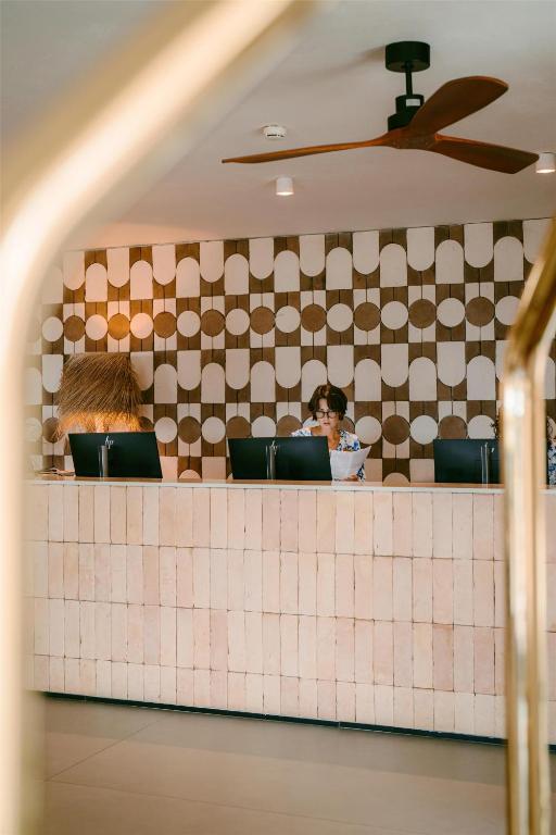 Mangia's Santa Teresa Sardinia viesnīcas reģistratūra ar dekoratīvu sienu.