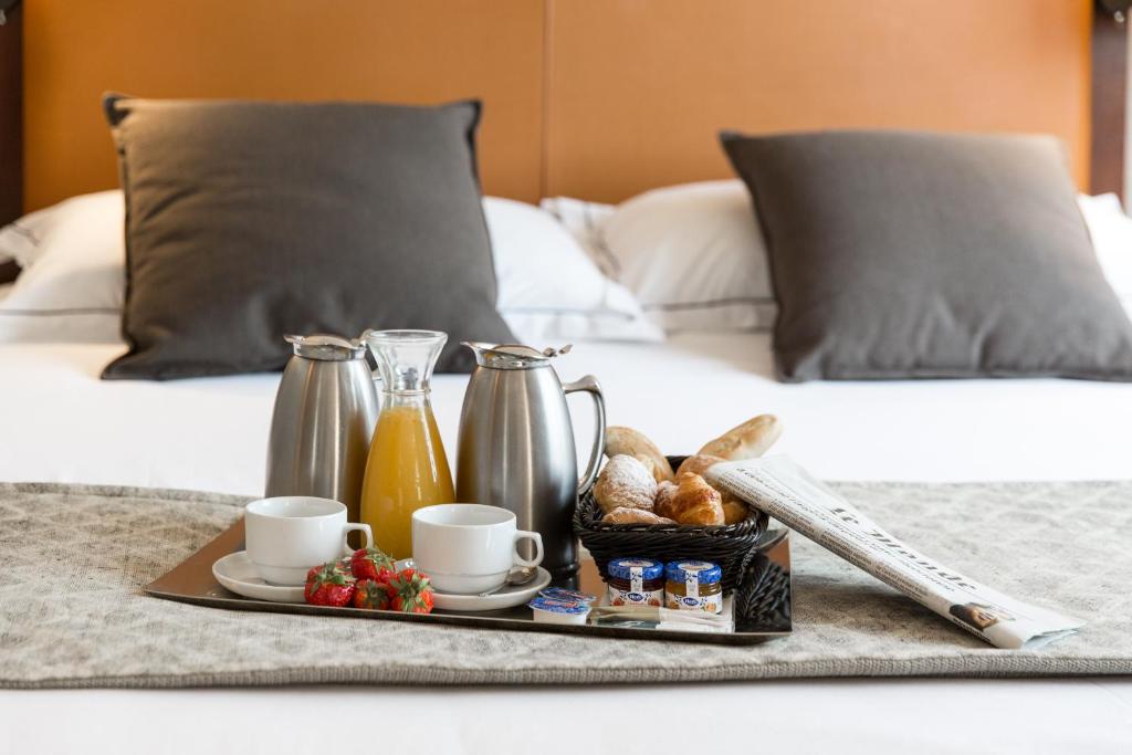 Brokastu komplekts ar kafiju, sulu un maizēm uz gultas. Komfortabla atmosfēra ar mīkstiem spilveniem un žurnālu.
