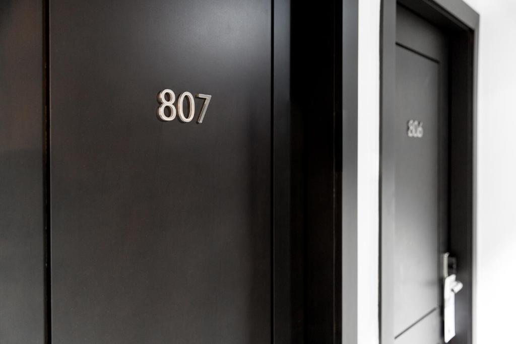 Melna durvju siena ar numuriem 807 un 806, kas norāda uz viesnīcas vai dzīvokļa numuriem.
