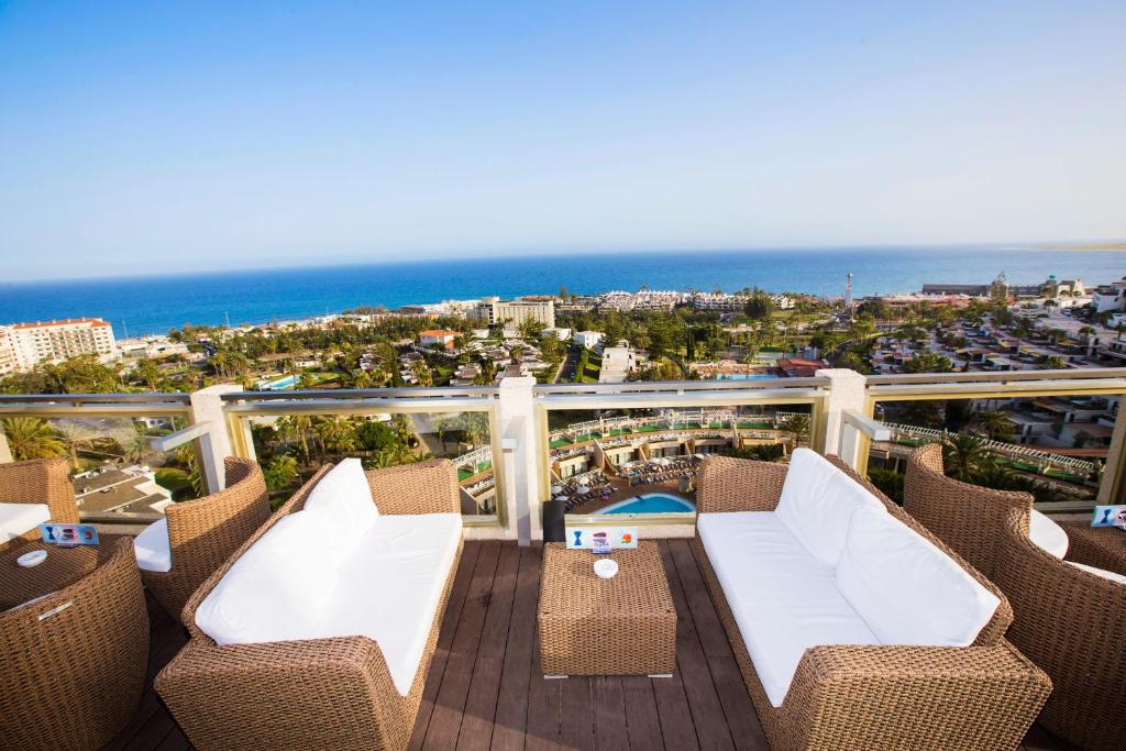 Skats no augšas uz viesnīcas terasi ar brīnišķīgu skatu uz jūru un apkārtējiem kūrortiem. Terasē ir ērtas mēbeles un relaksējoša atmosfēra.