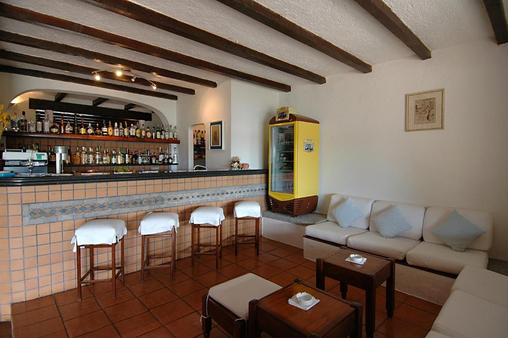 San Paolo viesnīcas mājīgs bārs ar koka sijām un sēdvietām.