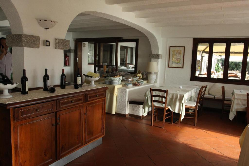 San Paolo viesnīcas restorāns ar vīna pudelēm un klātiem galdiem.