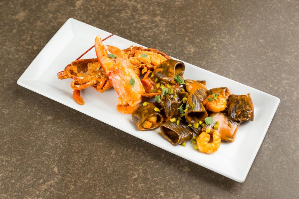 Svaiga jūras velšu plate ar garnelēm un krabju ķermeņiem, dekorēta ar zaļumiem. Ideāla izvēle jūras ēdienu mīļotājiem.