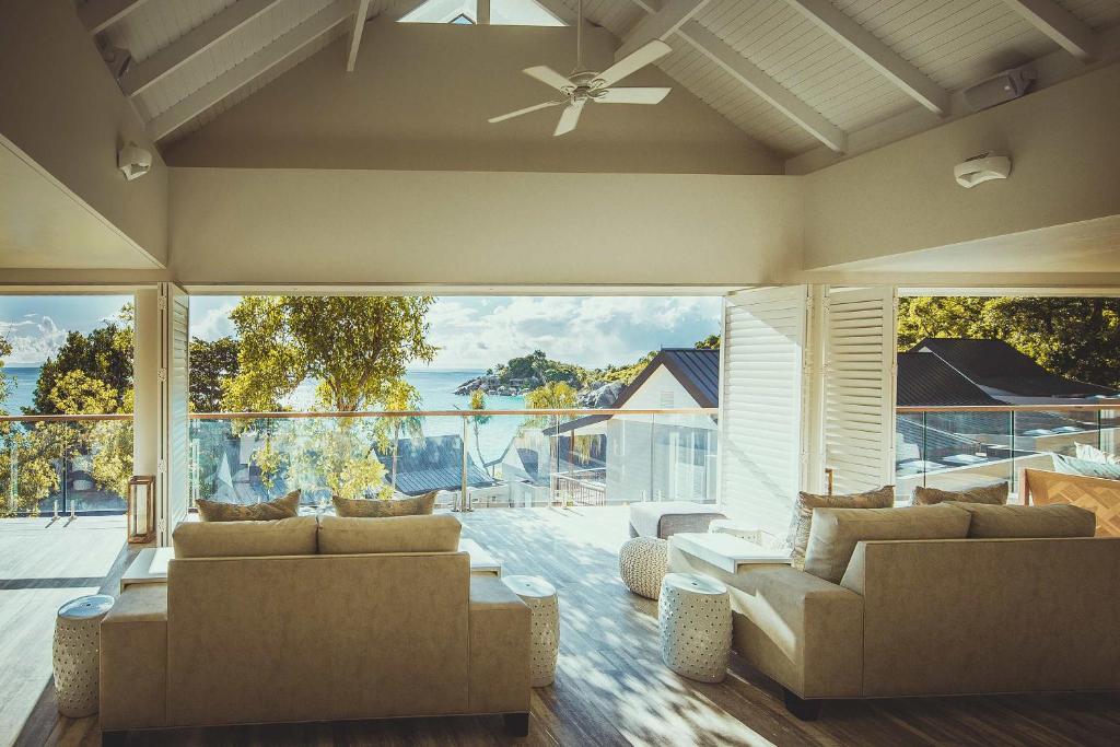 Mūsdienīgs interjers ar plašu skatu uz jūru, kurā redzamas ērtas dīvāni un izmēģinājuma terases. Gaismas pilna telpa ar koka grīdu un lieliem logiem, kas ļauj izbaudīt dabu.