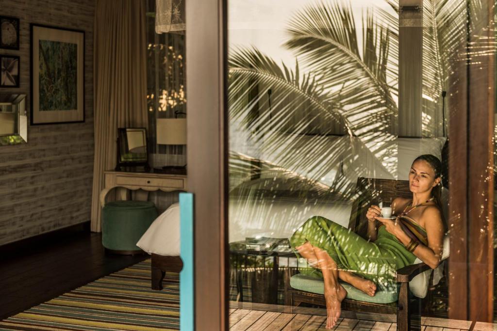 Four Seasons Resort Seychelles viesis bauda rīta kafiju privātā villas terasē.