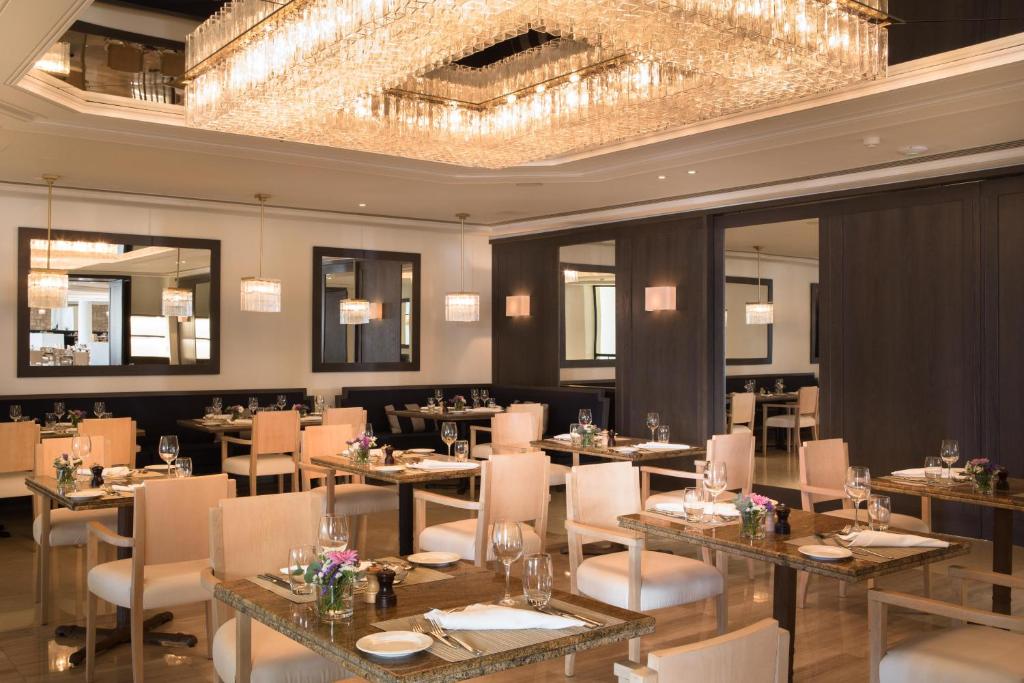 Mūsdienīgs restorāns ar elegantu interjeru, koka galdiem un krēslām, kas rotā ziedi. Lieliska atmosfēra ar krāšņu lustru, kas rada siltu gaisotni.