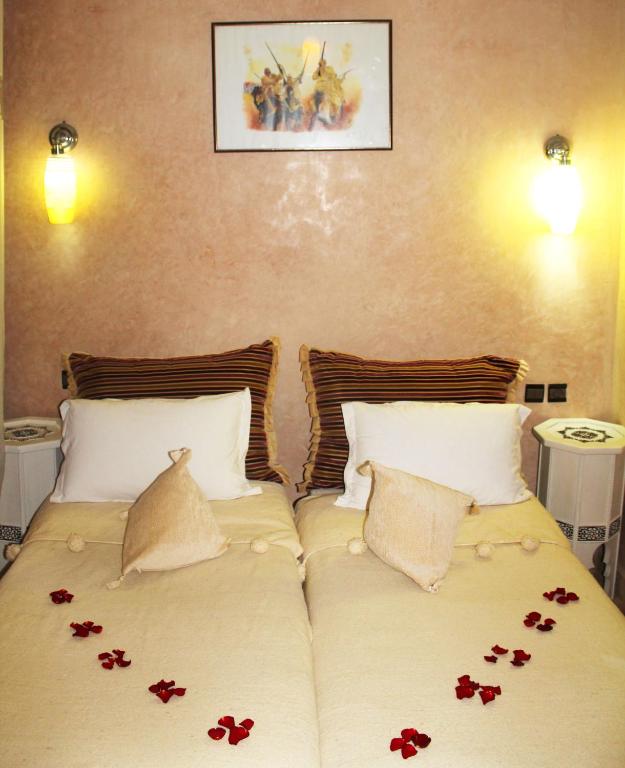 Gultas ar dekoratīvām spilveniem un rožu ziedlapiņām, kas veido romantisku atmosfēru, un sienas gaismas avotiem. Virs gultas ir gleznots attēls ar karotājiem.