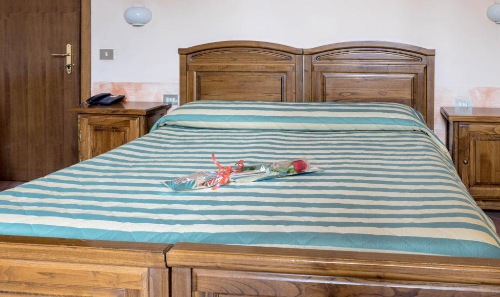 Mierīgā guļamistaba ar koka mēbelēm, kurā redzams gultas veļa ar svītrām un rozēm uz gultas. Ideāla vide romantiskai atpūtai.