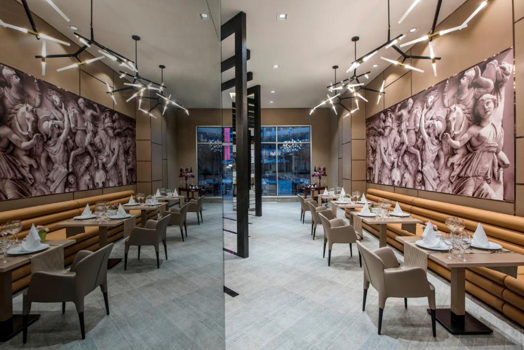 Mūsdienīgs restorāns ar elegantiem galdiem, moderna apgaismojuma sistēmu un stilīgām sienu gleznām. Svaiga un gaumīga atmosfēra, kas aicina uz baudāmām maltītēm.