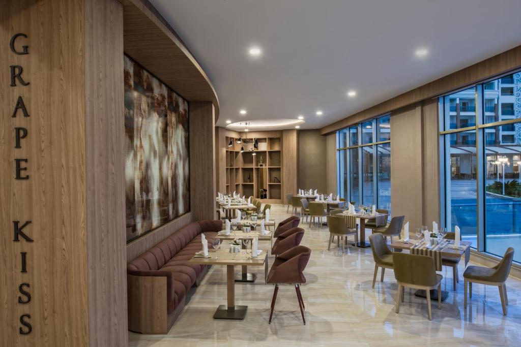 Moderns restorāns ar elegantiem koka elementiem un plašiem logiem, kas piedāvā skatu uz ārpusi. Interjers ir ērti iekārtots ar galdām un krēsliem, radot patīkamu atmosfēru.