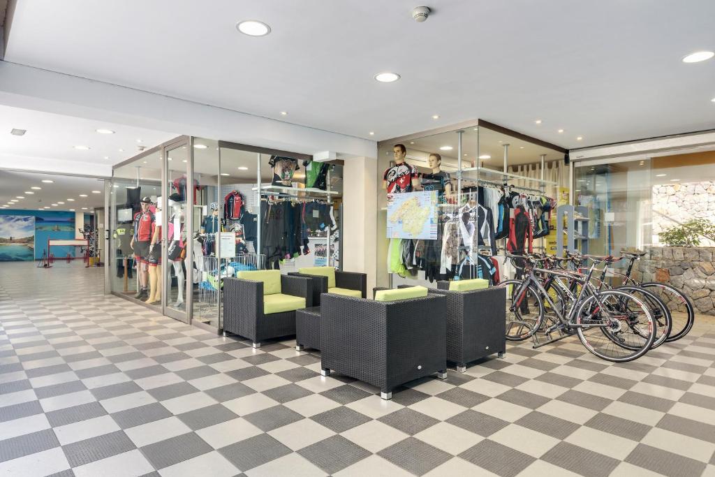 Veikala interjers ar sporta aprīkojumu un velosipēdiem, kurā ir ērti sēdekļi un modes manekeni. Telpa ir gaiša un moderna, ar flīžu grīdu un lieliem logiem.