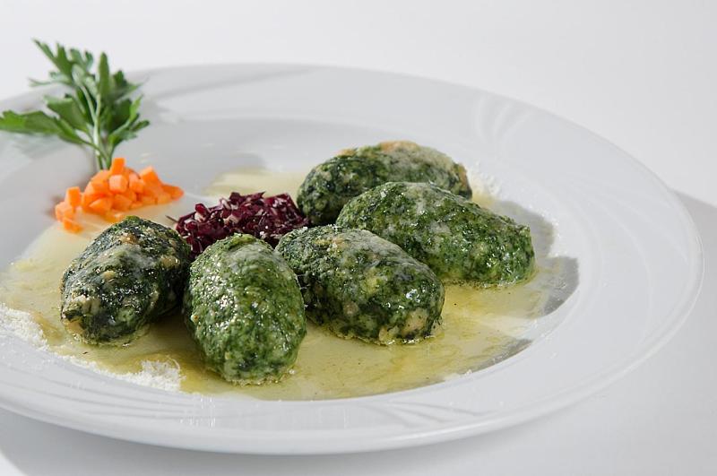 Zaļās dārzeņu kotletes ar mērci, pasniegtas ar burkānu un sīpolu garnējumu. Ideāli piemērotas veselīgām maltītēm.