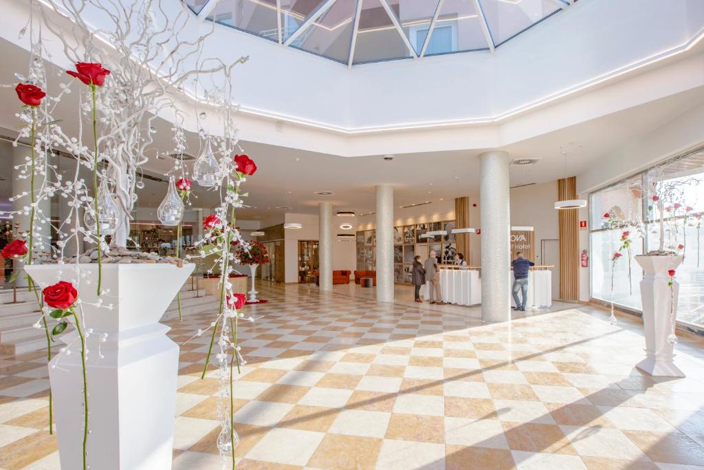 Skaists interjers ar ziedu dekorācijām un modernu arhitektūru, kas rada elegantu atmosfēru. Gaismas un telpas plānojums pievērš uzmanību un aicina apmeklētājus.