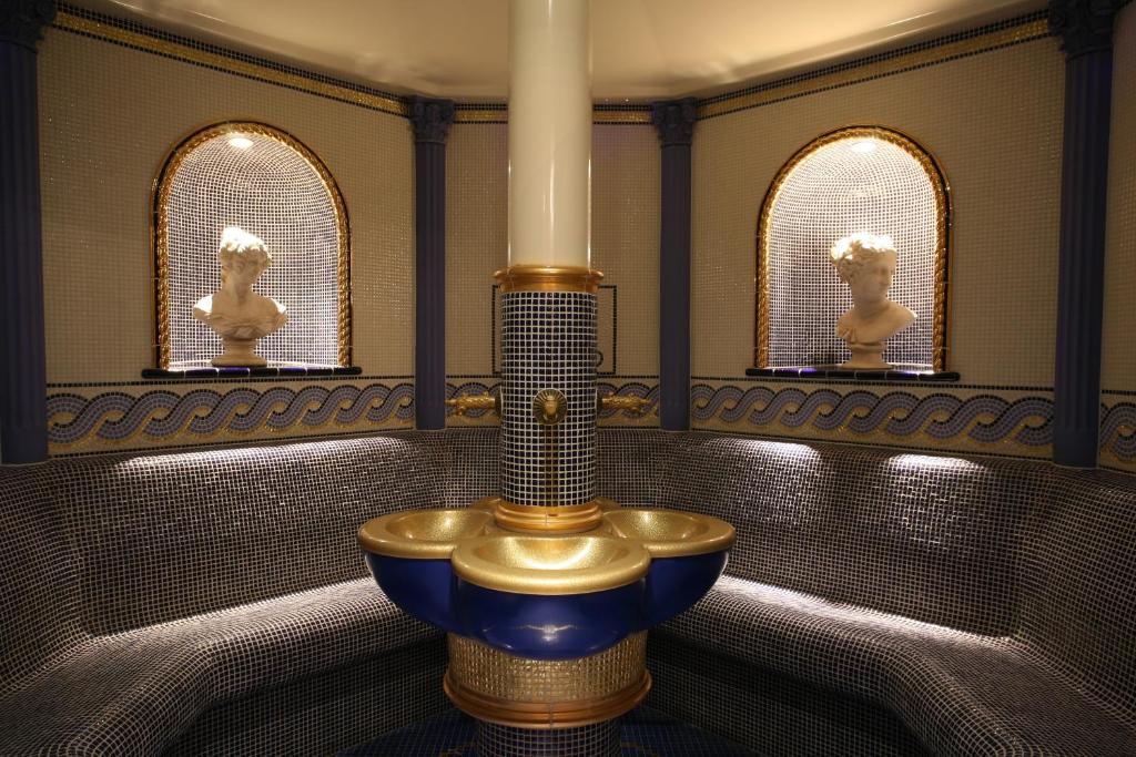 Šī liela, eleganta telpa ar mozaīkas apdari un greznām statujām piedāvā relaksējošu atmosfēru. Centrā atrodas dekoratīvs strūklaka, kas papildina telpas estētiku.