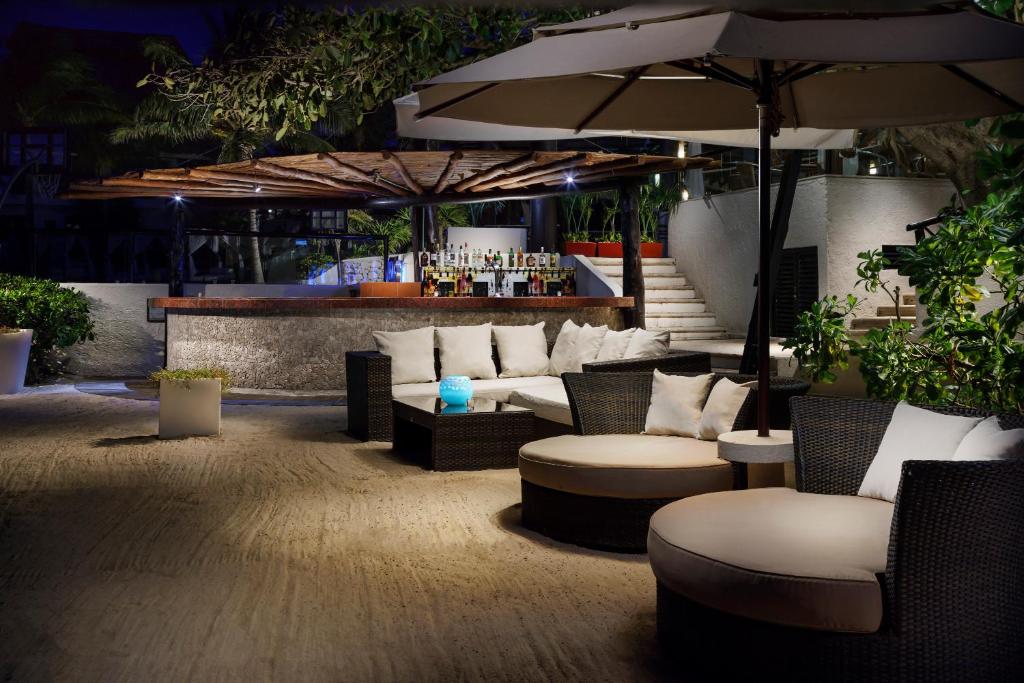 Eleganta āra atpūtas zona ar mīkstiem dīvāniem un lietussargiem, kas atrodas blakus bāram, apgaismota mīkstā naktī. Ideāla vieta relaksācijai un socializēšanai.