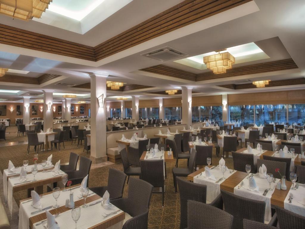 Elegants restorāns ar plašu ēdamzāli, kas izrotāta ar modernām lampām un stilīgiem galdiem. Gaisma un interjers rada patīkamu atmosfēru.
