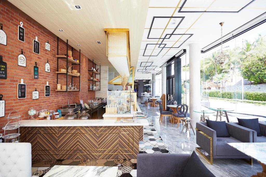 Mūsdienīgs kafejnīcas interjers ar ķieģeļu sienām, stilīgiem galdiem un krēsliem, kā arī plašiem logiem, kas nodrošina dabisko apgaismojumu. Dekorācija ietver izsmalcinātus aksesuārus un plauktus ar dažādiem produktiem.