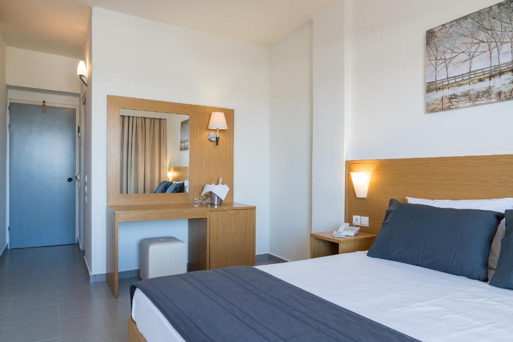 Mūsdienīgs viesnīcas numurs ar divguļamo gultu, koka mēbelēm un skatu uz dekoratīvu attēlu pie sienas. Numurā ir spogulis, lampas un ērta sēdvieta.