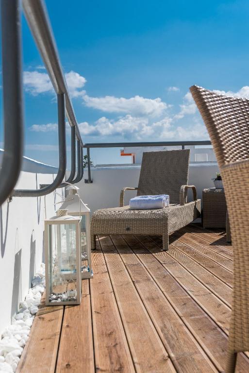 Saulaina terase ar komfortablām atpūtas krēsliem, koka grīdu un dekoratīvām gaismām, ideāla atpūtai brīvā dabā.