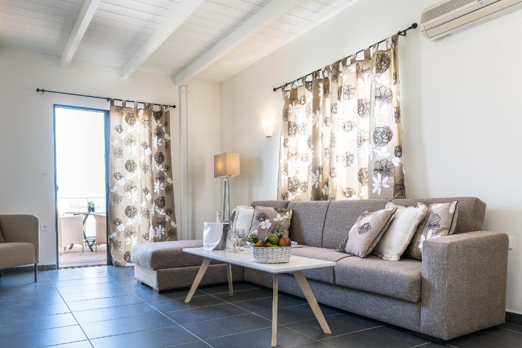 Mūsdienīgi iekārtots viesistaba ar gaišām aizkariem, dīvānu un galdiņu, uz kura atrodas augļi. Telpa ir gaiša un plaša, ar piekļuvi terasei.