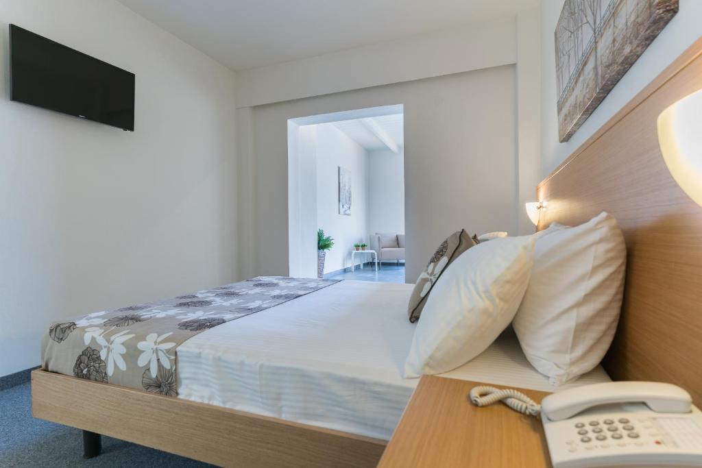 Mūsdienīgs viesnīcas numurs ar divguļamo gultu, televizoru un telefona ierīci uz naktsgaldiņa. Telpa ir gaiša un ērta, ar piekļuvi viesistabai.